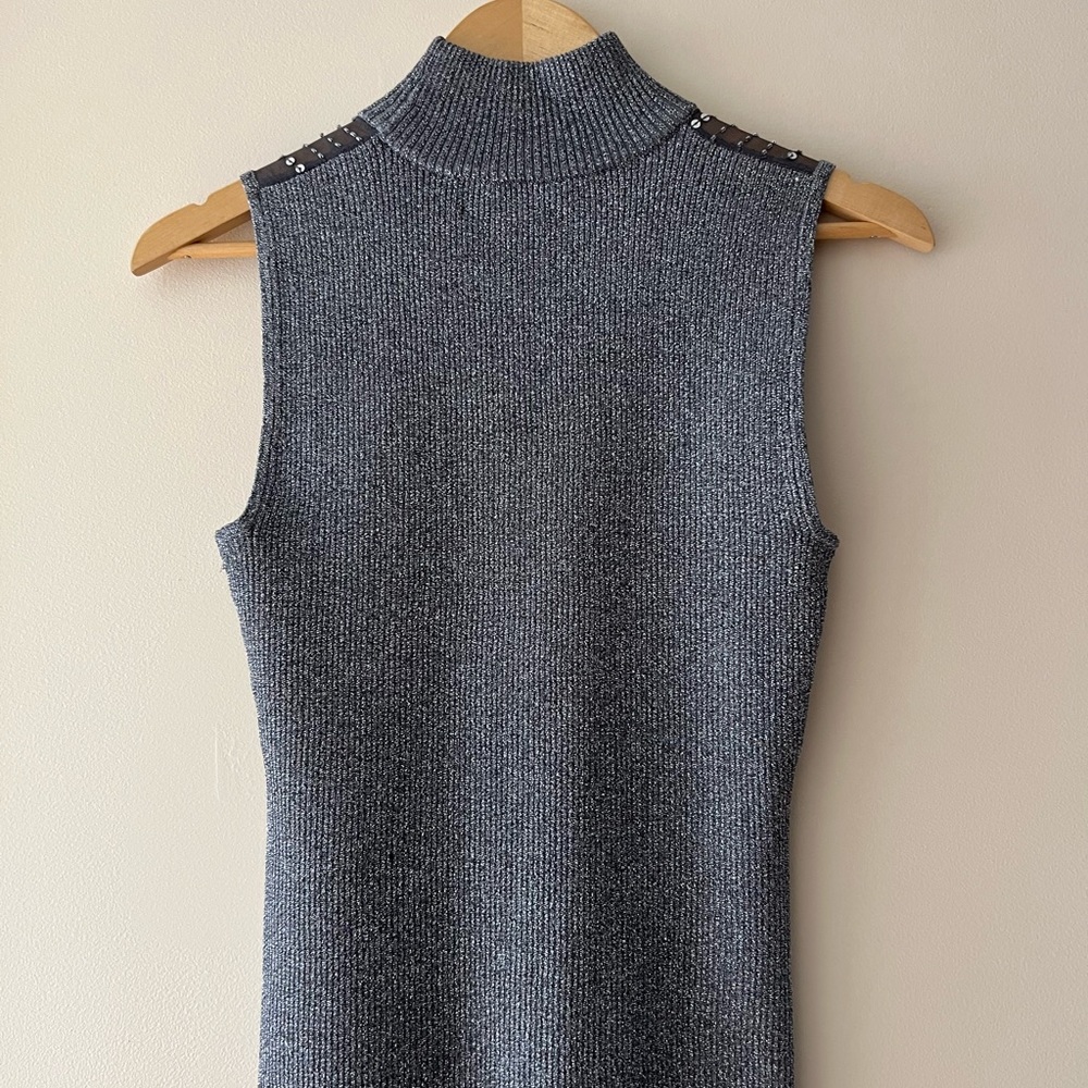 im selling this shirt that is grey and black with cute designs on the shoulders